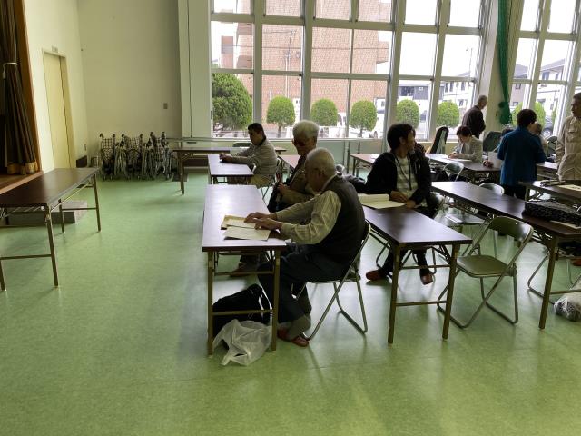 会場を横から、人がたくさん、窓の外の風景も