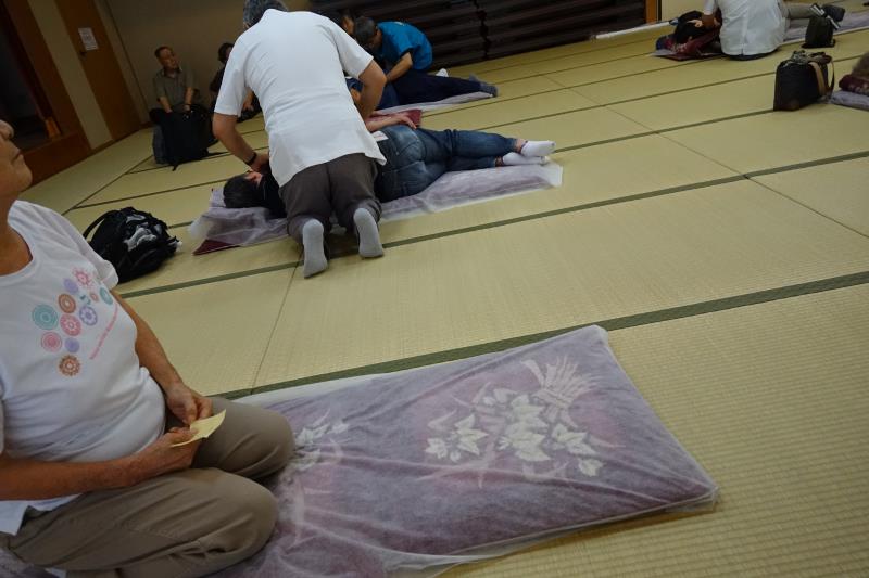 施術風景、向こうには大気中の人も